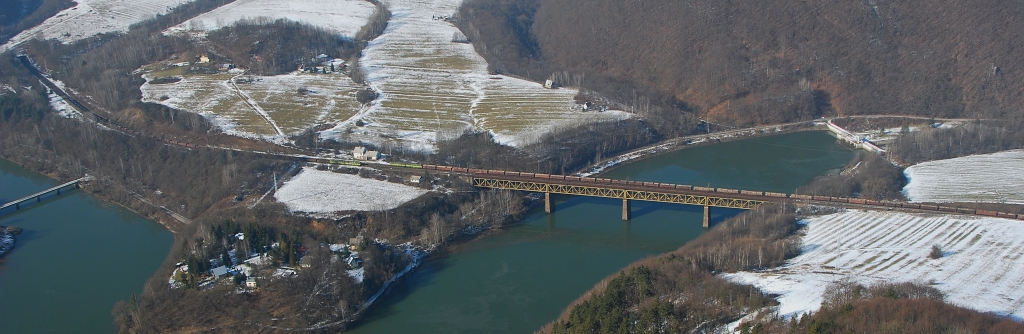 Panoramatický pohľad z vrchu Holica na stretnutie nákladných vlakov ZSSK CARGO v čele s „dvojičkami“ radu 131 na zastávke Ružín, fotené dňa 14.2.2015.
